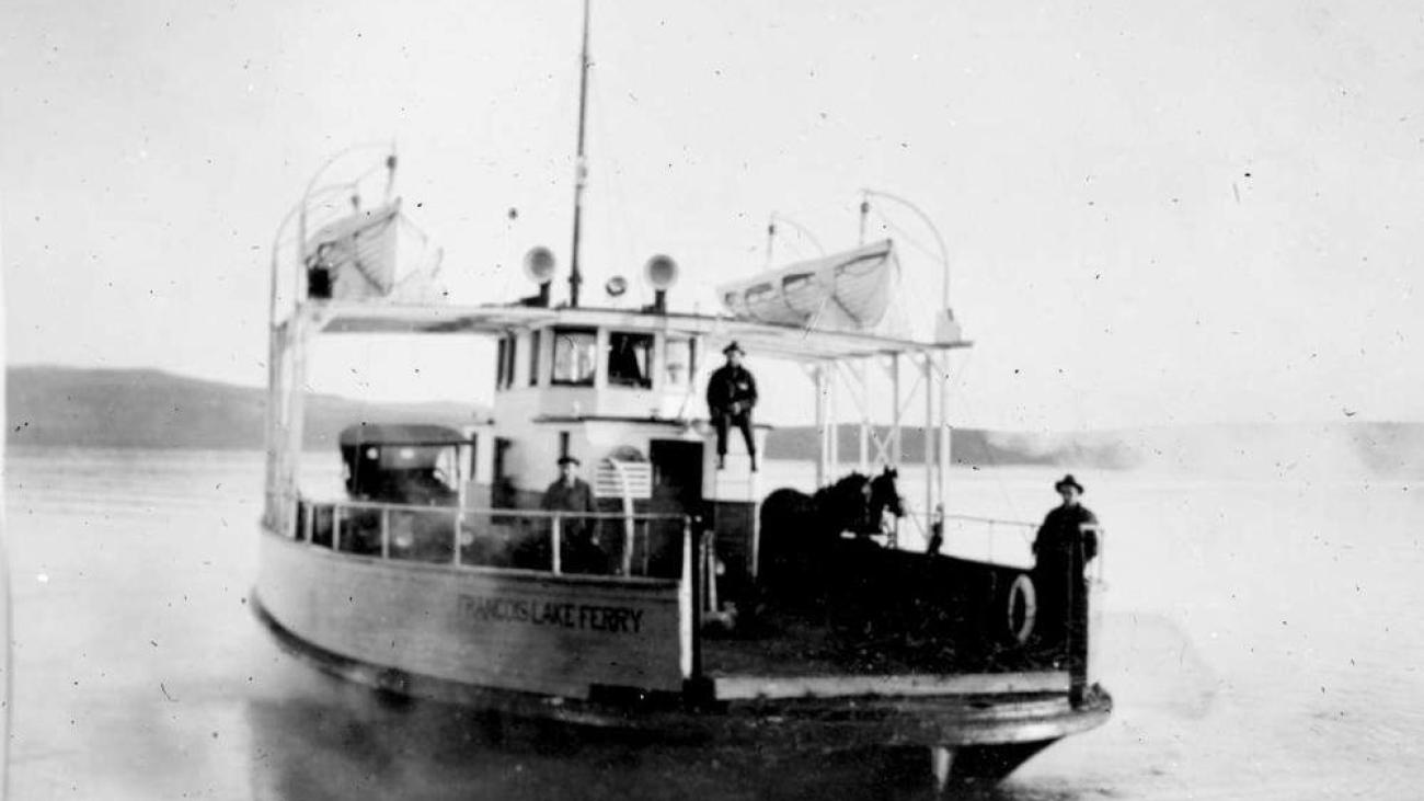 Small ferry boat with people on deck.