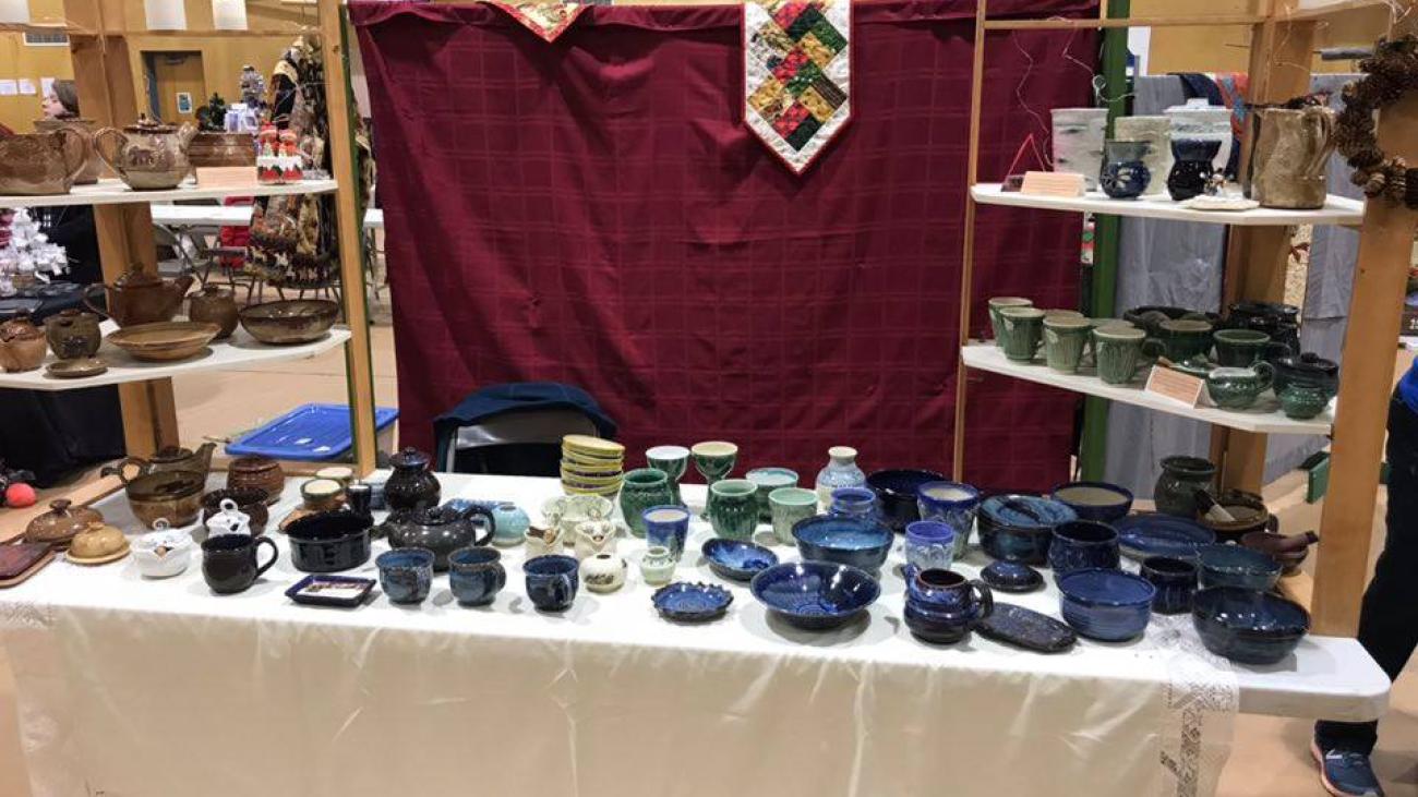 Ceramic pottery displayed on a table in a craft fair setting.